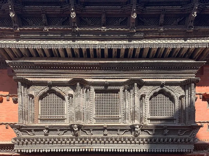 Rows of finely carved dark wooden windows and panels on a brick palace wall