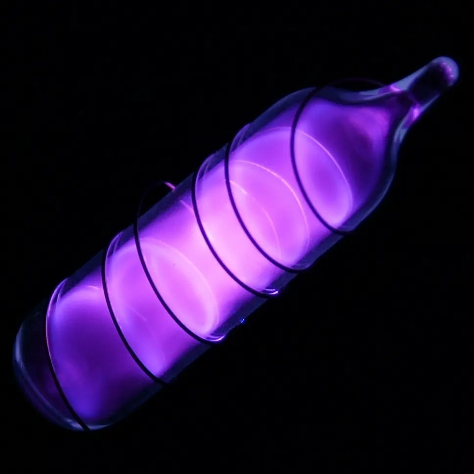 A small sealed glass vial glowing bright violet in the dark, with a wire coiled round it