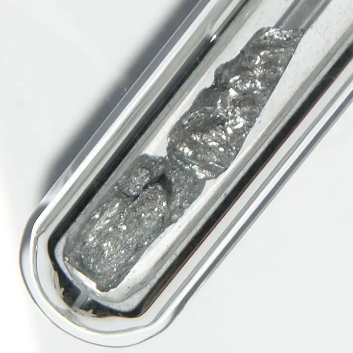 A few lumps of shiny, steel-gray crystals sealed inside a glass tube