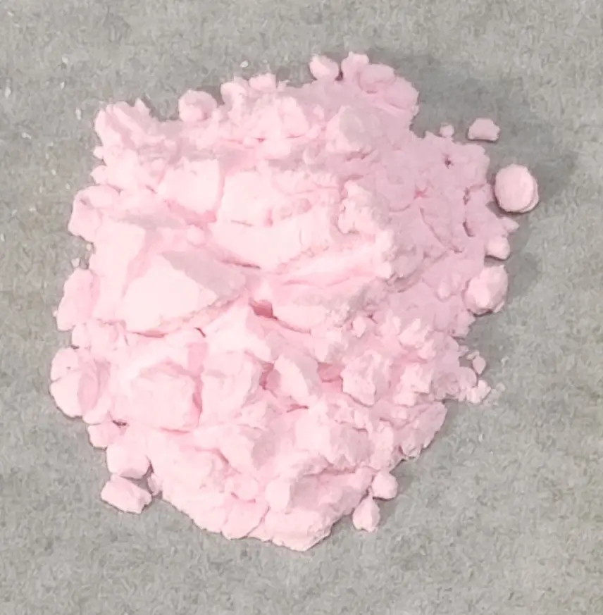 A small heap of soft, pale pink powder on a gray surface