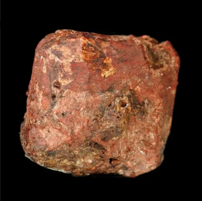 A rough, blocky reddish-brown crystal of a mineral on a black background