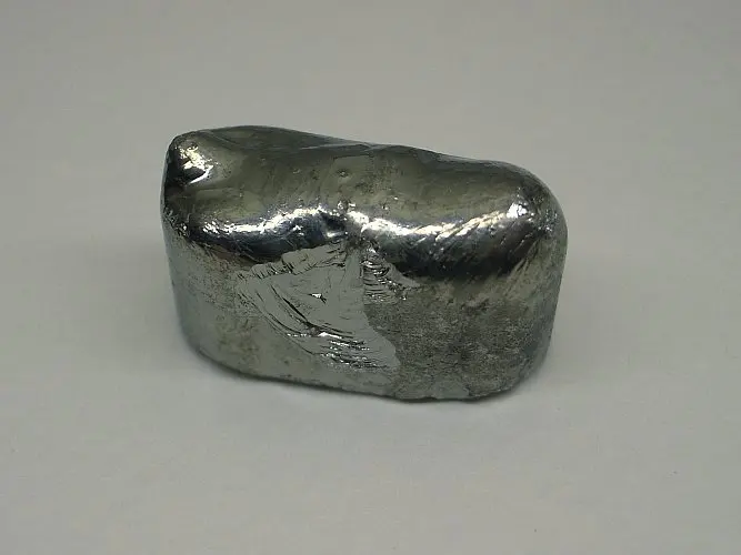 A rounded, loaf-shaped lump of shiny gray metal-like material, mirror-bright on top