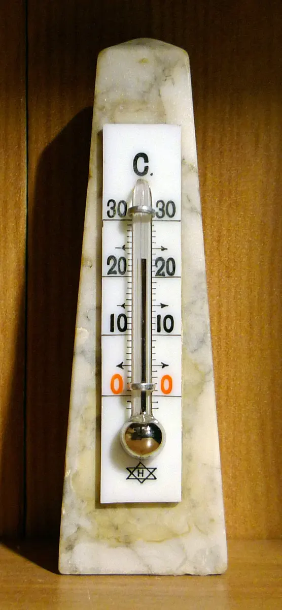A small thermometer on a white marble stand, with a silver bulb at the bottom and a thin silver thread rising to just above 20 on a scale from 0 to 30 °C
