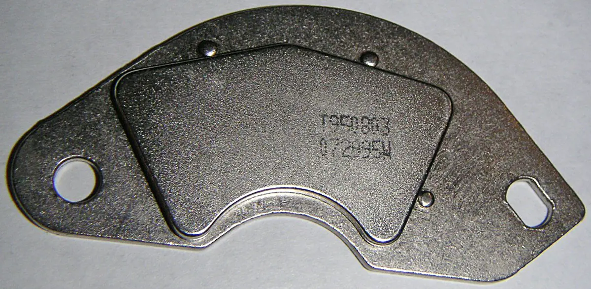 A flat, curved, silver-gray magnet fixed on a metal bracket with screw holes