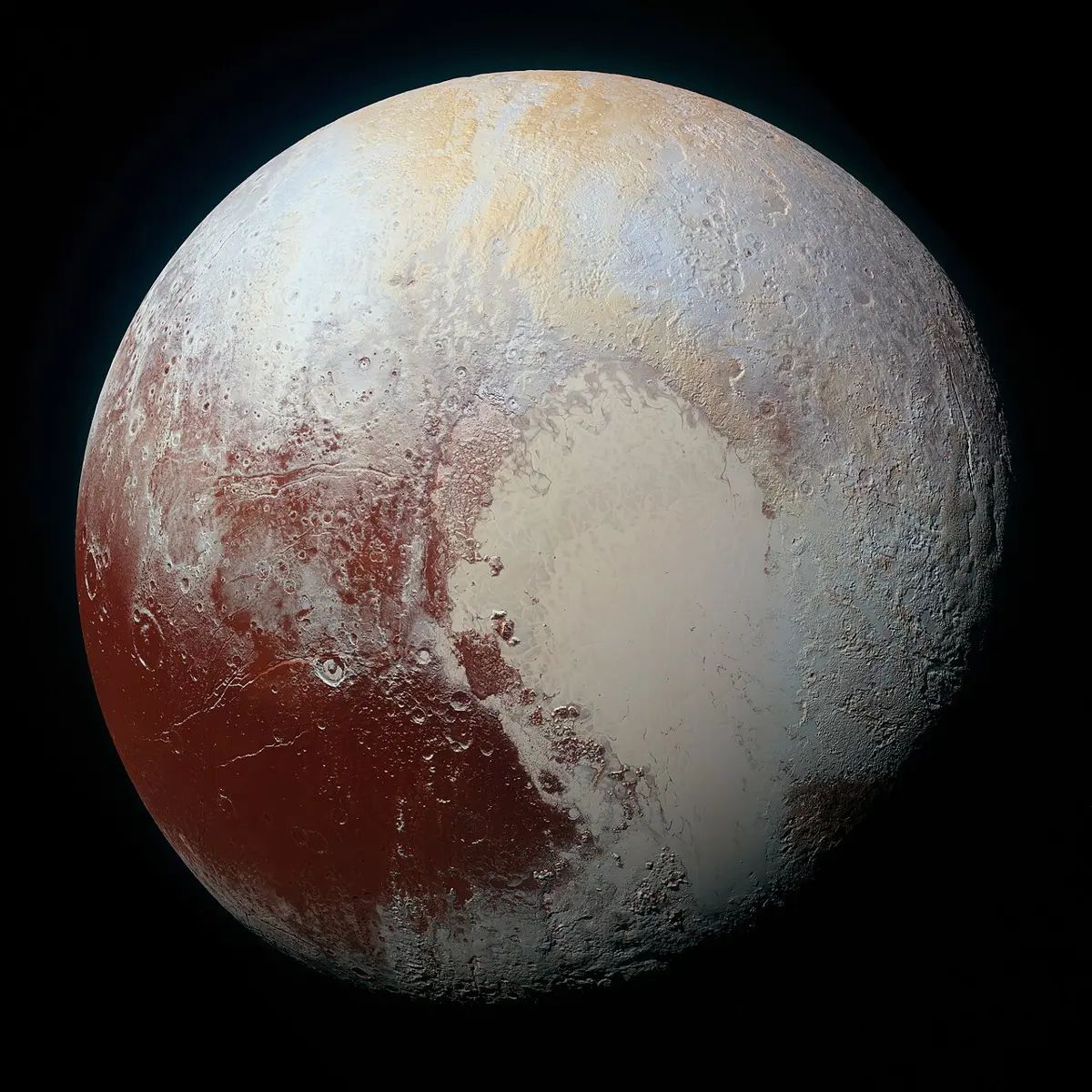 The dwarf planet Pluto: a round globe in shades of cream, pale blue and dark red, with a large, smooth, pale heart-shaped region in the middle and lower right