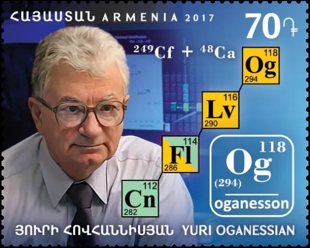 A postage stamp from Armenia, 2017: a portrait of a man with white hair and glasses beside the boxes of elements 112, 114, 116 and 118, linked by arrows, with the reaction californium-249 plus calcium-48 written at the top