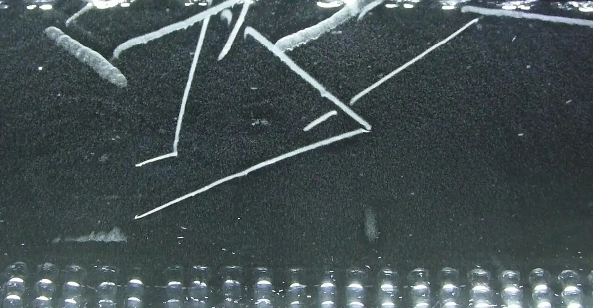 Thin white straight lines on a black background, several of them meeting in pairs to form sharp V shapes