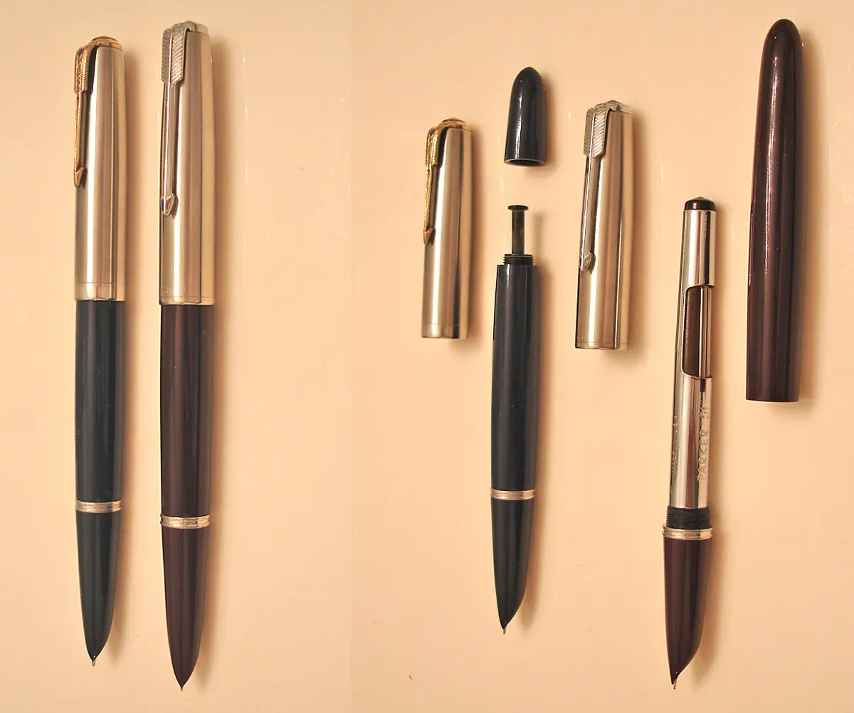 Two fountain pens with shiny metal caps and dark bodies, one blue-black and one maroon, and beside them two more taken apart into cap, body and barrel