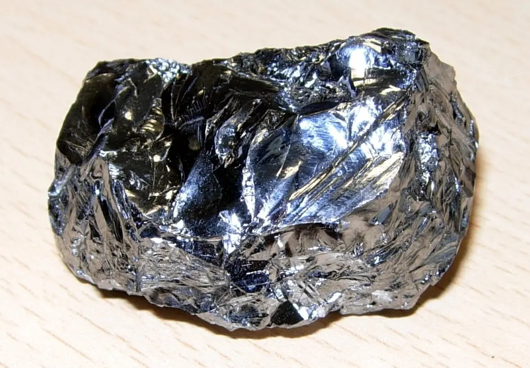 A lump of dark blue-gray material, glittering like a metal, with sharp, broken faces