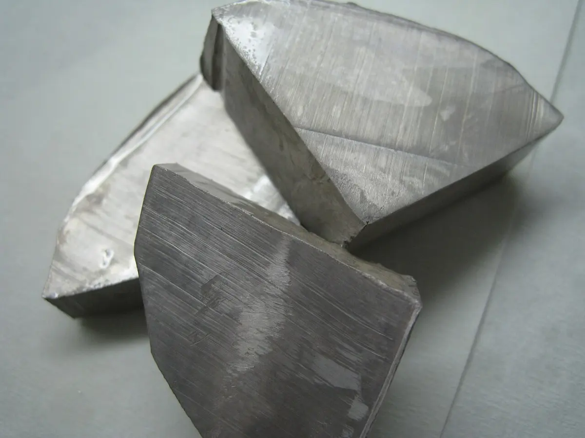 Three flat-cut lumps of gray metal, their faces streaked with knife marks