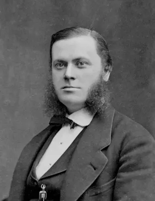 An old black-and-white portrait of a young man with side whiskers, a bow tie and a dark jacket