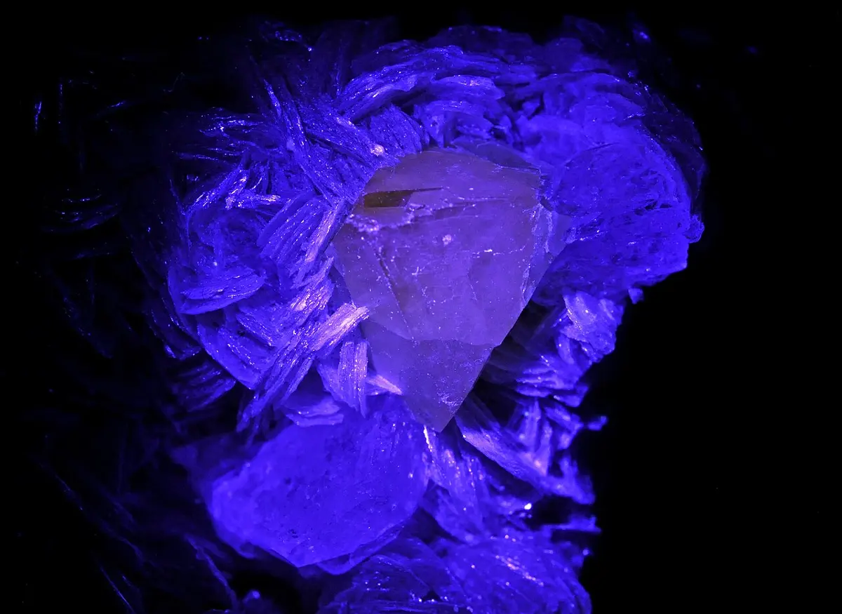 Crystals glowing bright violet-blue against a black background