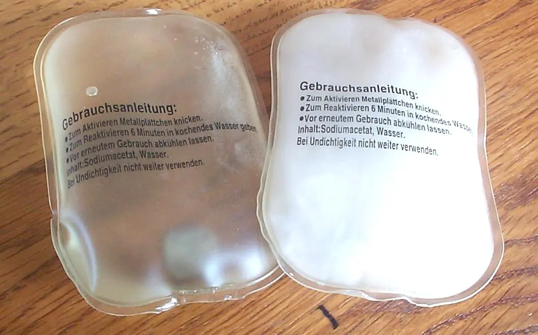 Two plastic pouches on a table: the left one full of clear liquid, the right one filled with white solid crystals