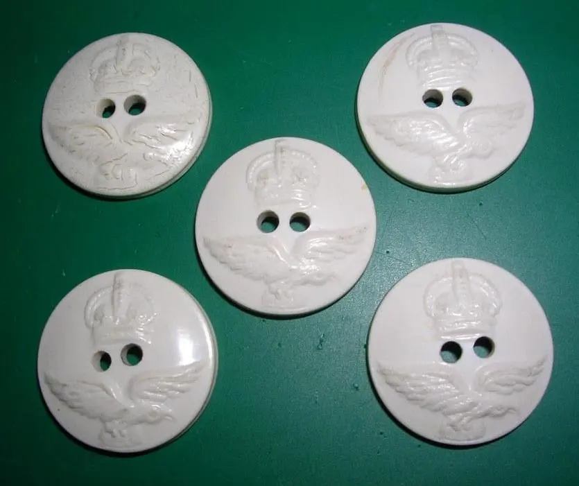 Five round white buttons, each with two holes and a raised crown and eagle