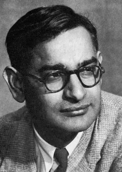 A black-and-white portrait photograph of a man with dark hair and round glasses, in a jacket and tie