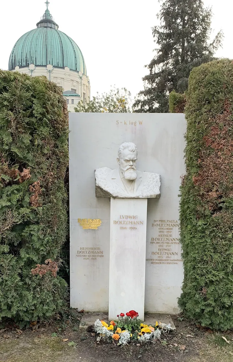 A white marble bust of a bearded man on a tall stone, with an equation carved above it