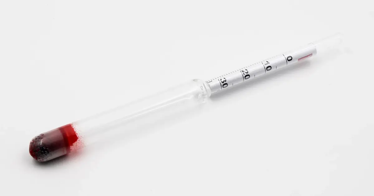 A glass hydrometer: a thin tube with a scale, weighted at the bottom with a bulb of red-coated shot