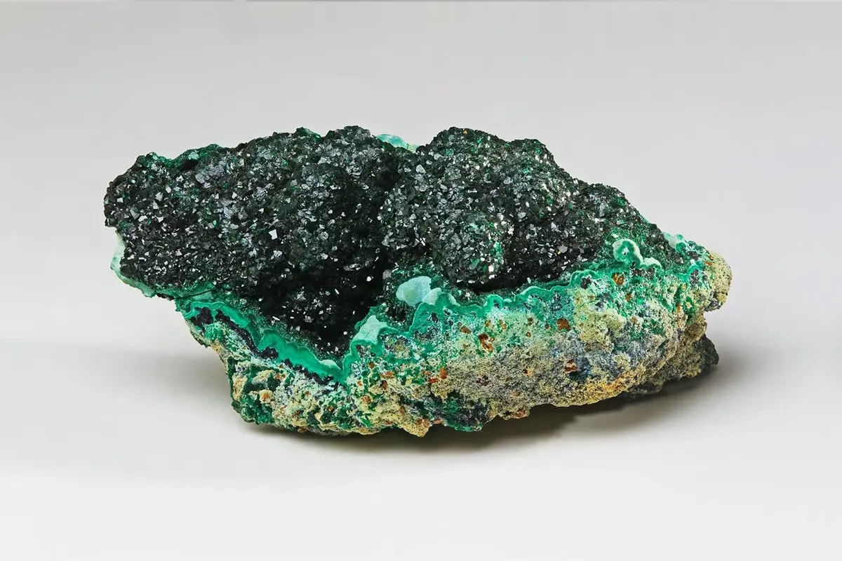 A lump of malachite: dark green, rounded and velvety on top, bright green below
