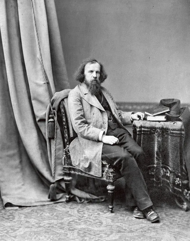A black-and-white photo of Dmitri Mendeleev, seated, with long hair and a long beard