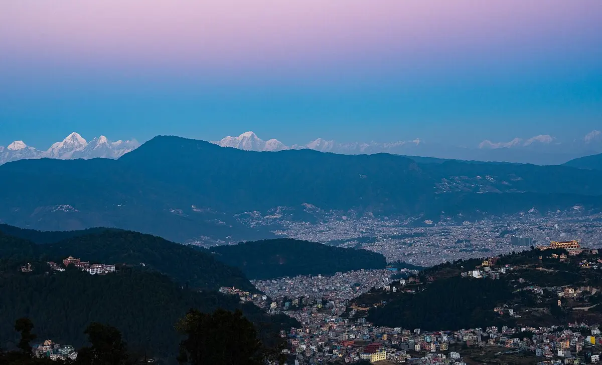साँझपख काठमाडौँ उपत्यका: उपत्यकाको फाँट घरैघरले भरिएको र अगाडि वनले ढाकिएका डाँडामा पनि घर फैलिँदै गएका