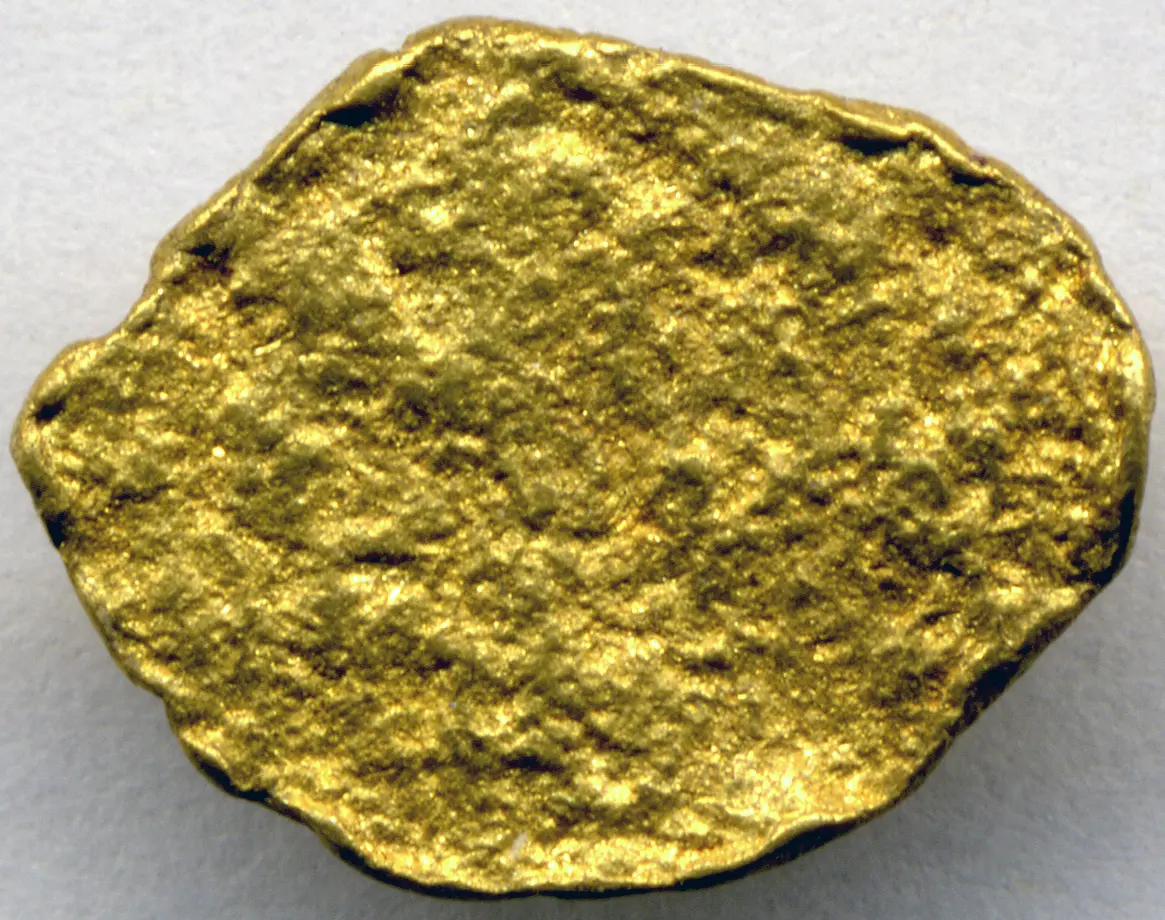 A small, rounded, bright yellow nugget of gold