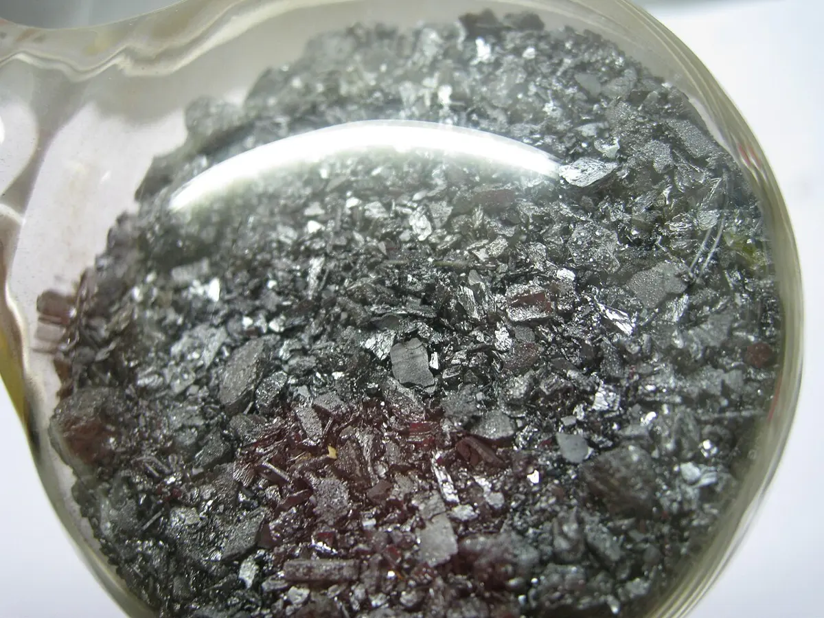 Small shiny, dark gray-violet crystals of iodine