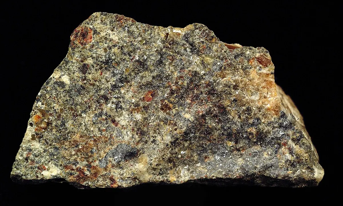 A rough gray-brown rock speckled with dark, shiny grains of zinc blende