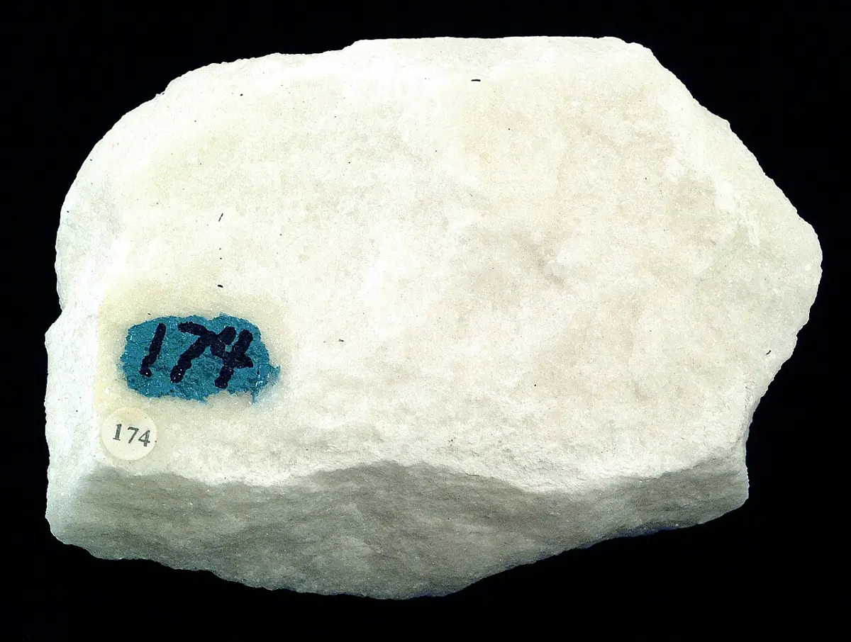 A white, sugary-looking block of rock with glittering crystals