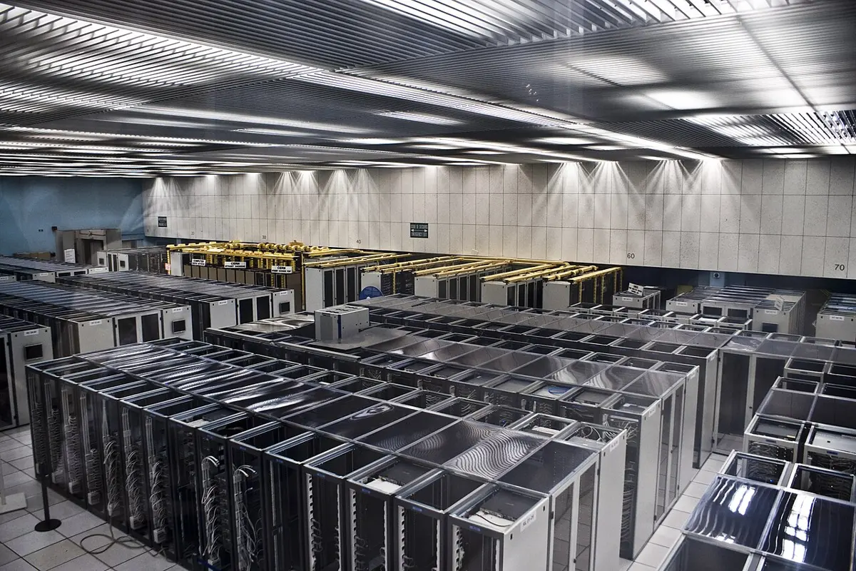 A large hall with long rows of cabinets full of servers