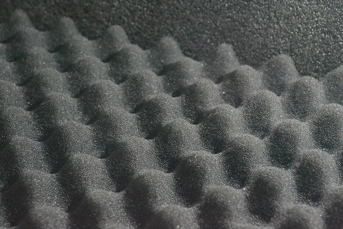 A close-up of dark gray foam shaped into rows of rounded bumps, like an egg tray