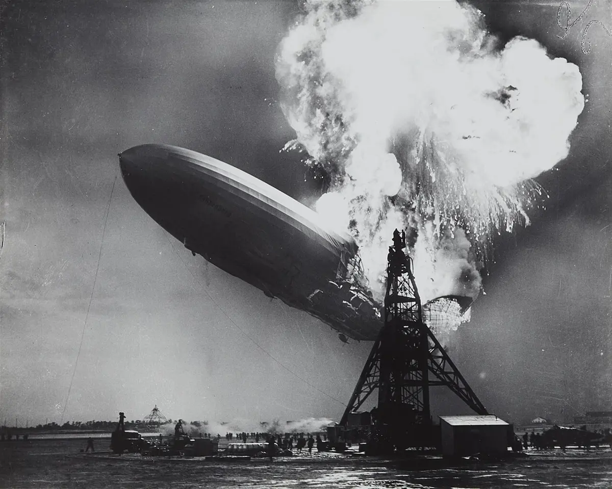 A huge airship engulfed in flames and smoke, its tail sinking towards the ground