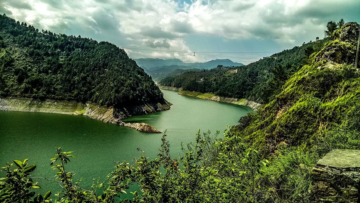 A long green lake winding between steep forested hills