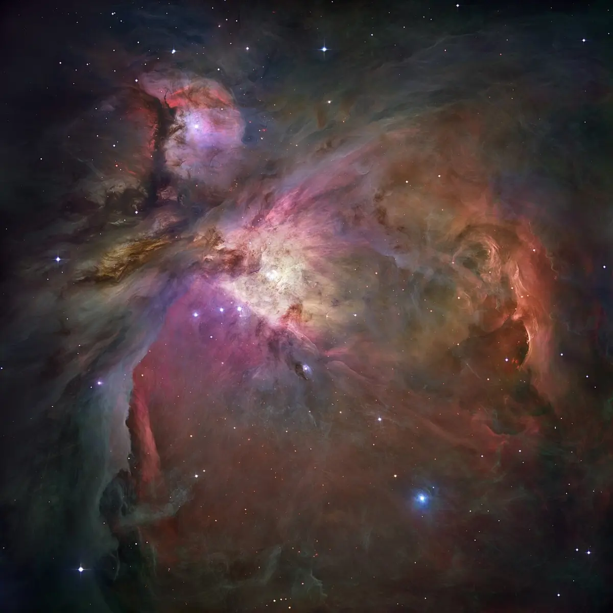 A glowing cloud of gas in shades of orange, red and blue, with many bright stars scattered through it
