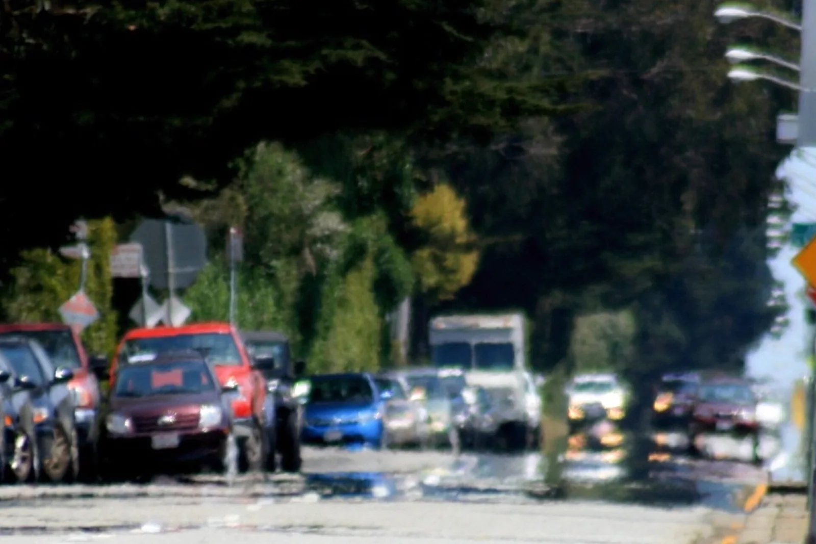 A road on a hot day where cars seem to be reflected in a pool of water
