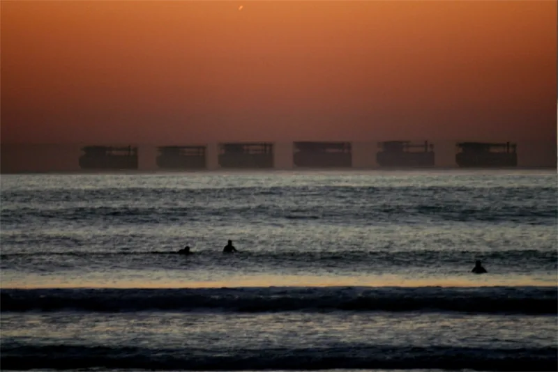 A boat on the horizon at sunset, stretched into a tall shape like a castle