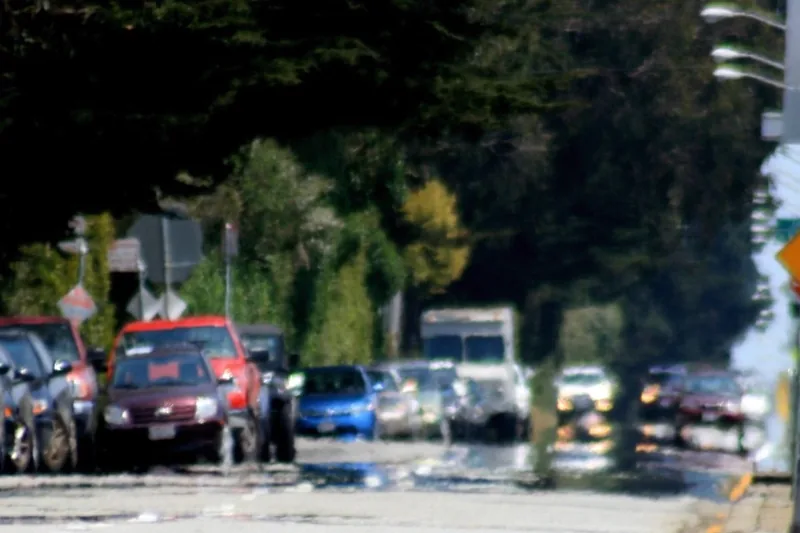 A road on a hot day where cars seem to be reflected in a pool of water