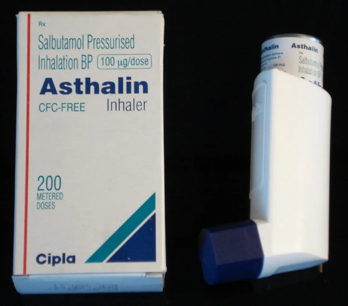 A white box labeled Salbutamol Pressurised Inhalation, Asthalin Inhaler, 200 metered doses, next to a white inhaler with a dark blue cap
