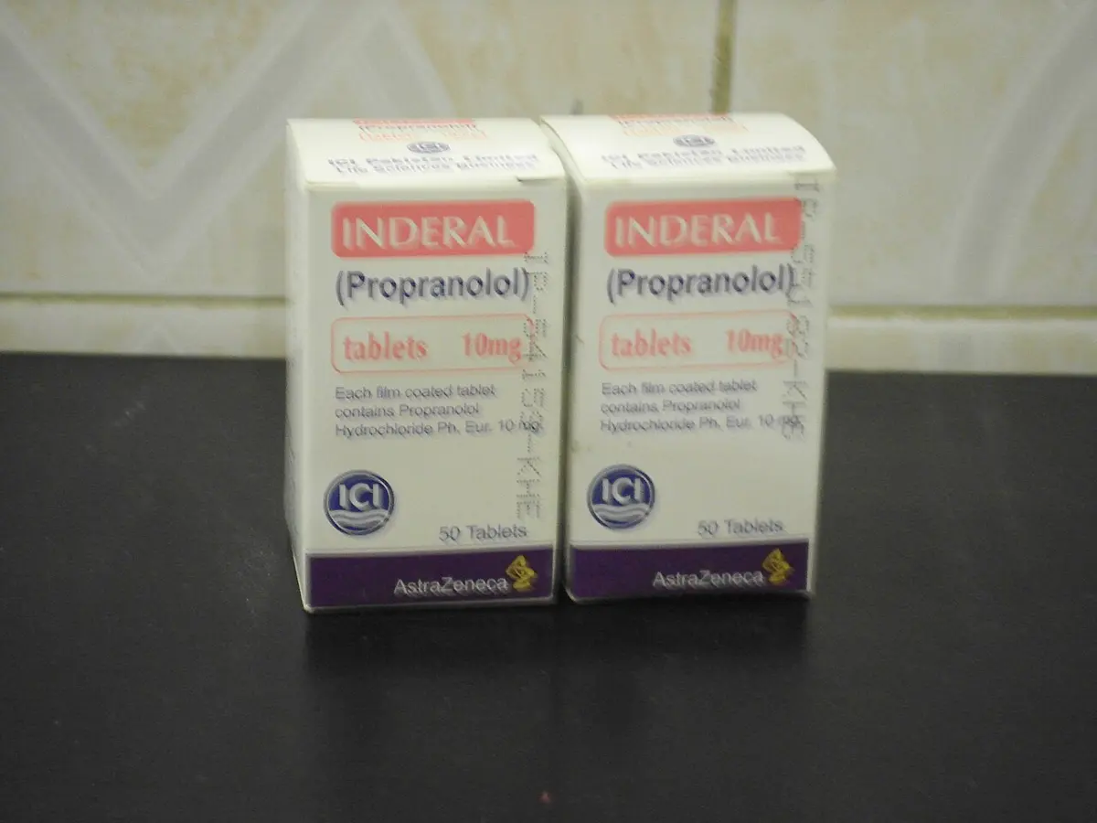 Two small white boxes labeled Inderal (Propranolol) tablets 10 mg, standing on a dark table