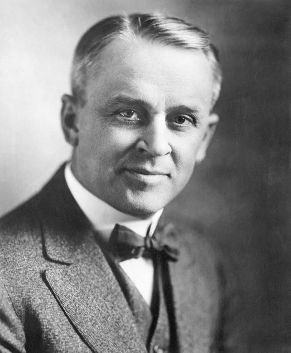 Black-and-white portrait of Robert Millikan, a man with graying hair, in a tweed jacket and bow tie