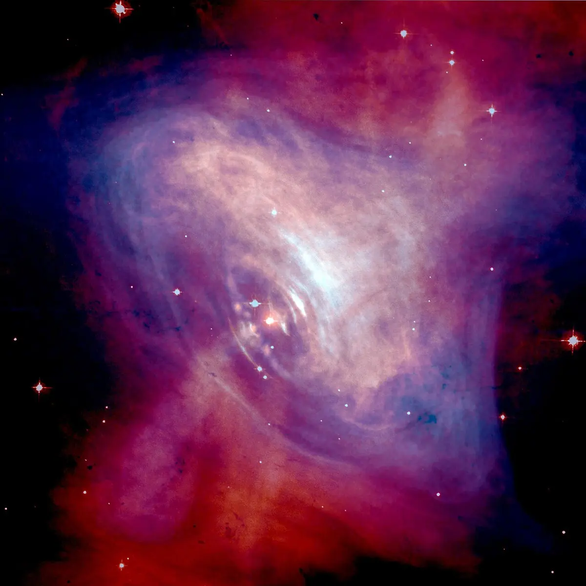 A glowing cloud of red, purple and blue gas against a black sky with a few stars, with a bright point and rings of light near its middle