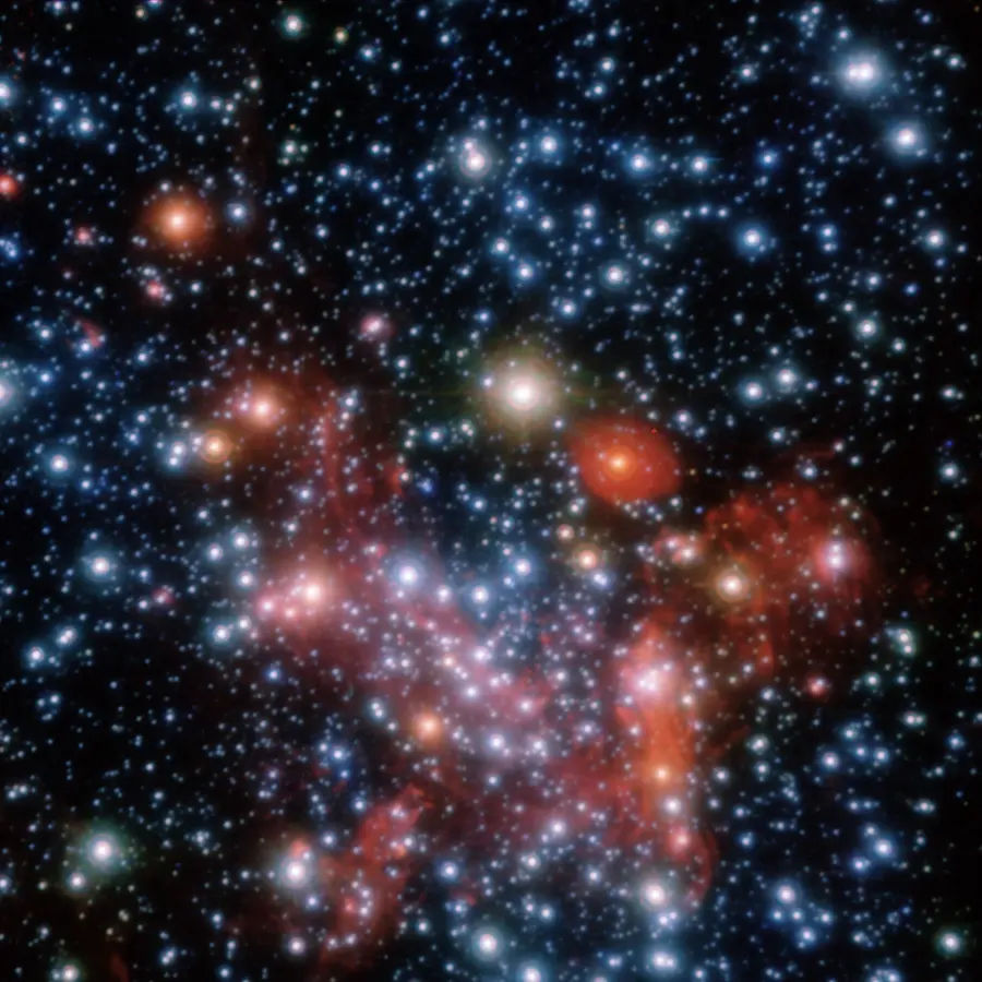 A dense crowd of hundreds of white, blue and orange star points on black, with patches of red glowing gas between them