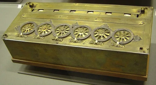 A brass box with a row of numbered dials on top and windows showing digits