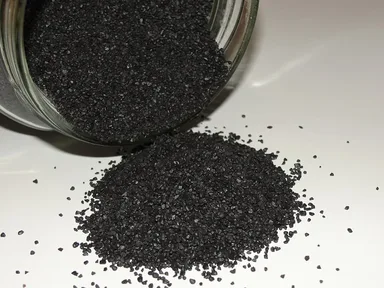 Black gunpowder grains in a glass jar