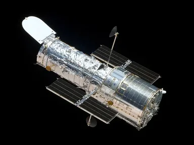 The Hubble Space Telescope in orbit above the Earth, its solar panels spread out