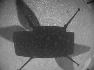 Black-and-white photo from Ingenuity’s camera of its own shadow on the Martian ground during its first flight