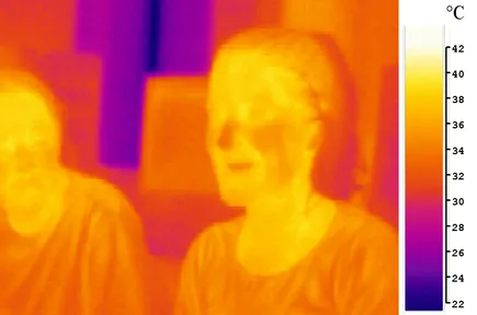 A picture of a girl taken with an infrared camera: her warm face glows yellow and white, her cooler hair and glasses look dark