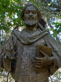 A stone statue of al-Khwarizmi in a turban and robe, in Madrid