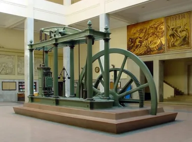 A large Watt-type steam engine with a beam, a flywheel and a tall frame, in a museum