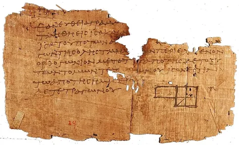 A torn scrap of ancient papyrus with Greek writing and a drawing of a square divided into smaller shapes