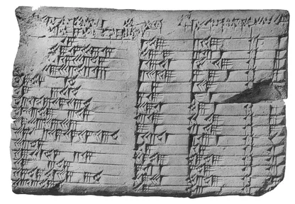 A small, broken clay tablet covered in rows of wedge-shaped numbers